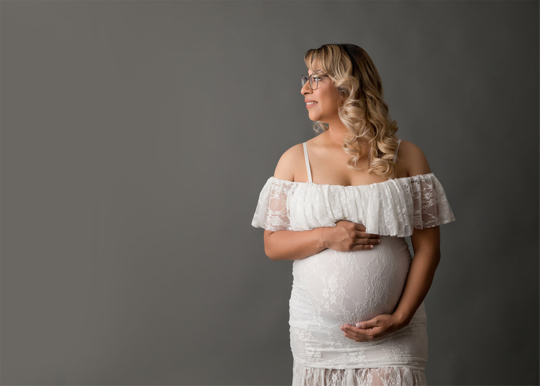 Pregnant woman in white dress, gray background